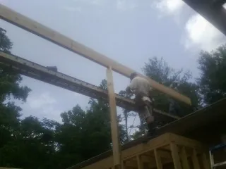 Carpenter setting a ridge beam over a new addition frame — Ice Dam Removal by Roofing Brothers in Paulsboro