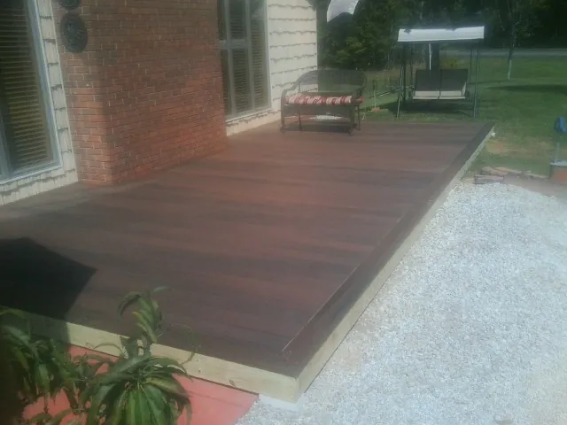 Freshly stained wood deck built against a brick home in Paulsboro