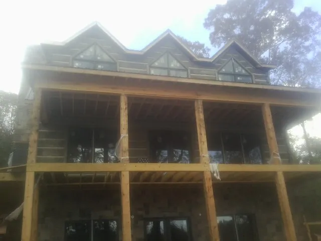 Dormers and porch framing on a large log home under construction — Roof Coating work by our crew in Paulsboro