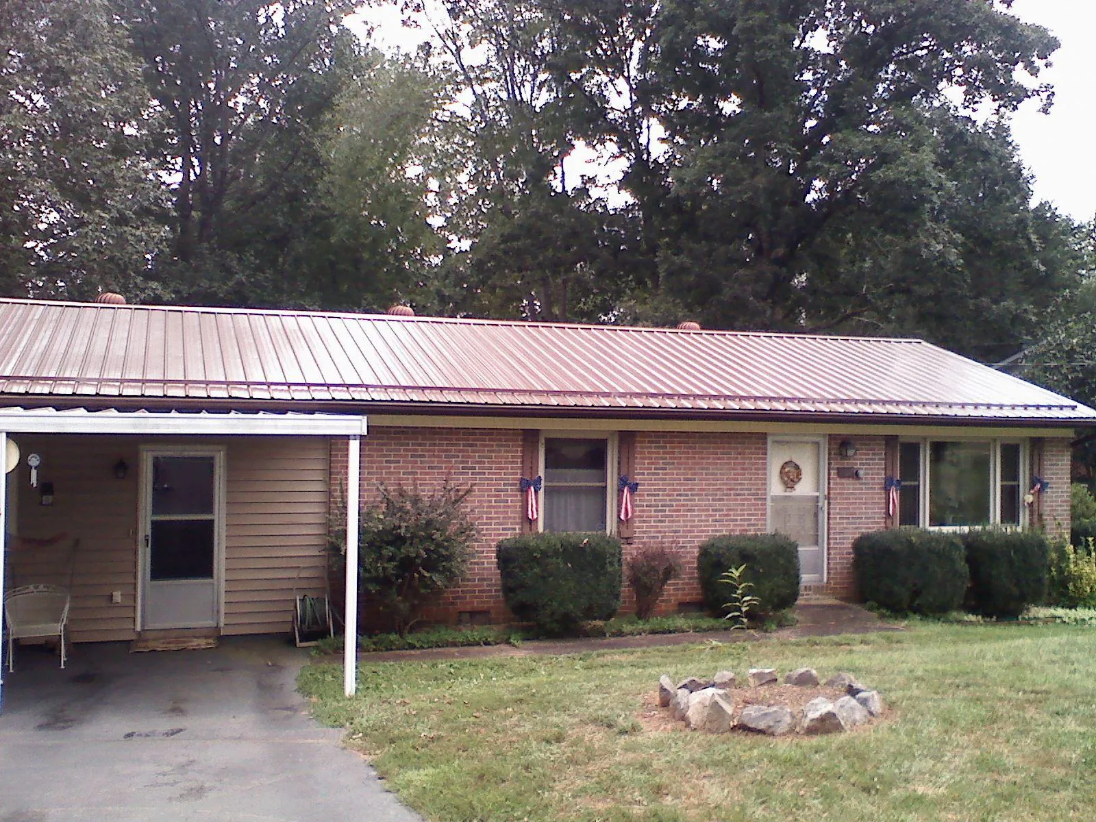 Bronze metal roof and carport on a brick ranch home — Roof Repair work by our crew in Paulsboro